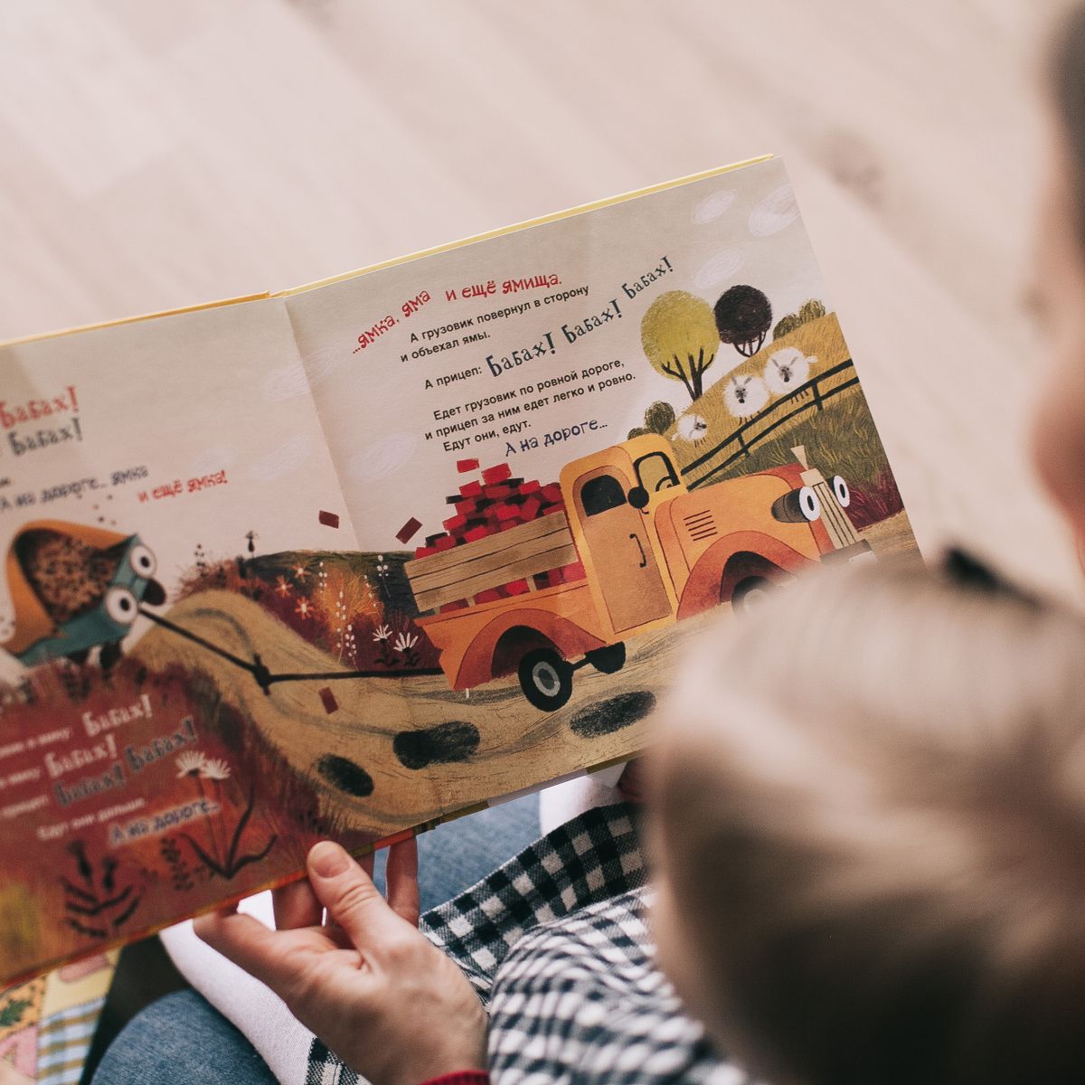 A parent and child reading a Fenous picture book together